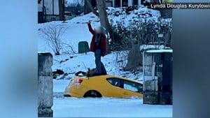 Șocant! O femeie care a căzut cu maşina într-un râu înghețat s-a urcat pe mașină să facă un selfie, în timp ce mașina se scufunda. FOTO